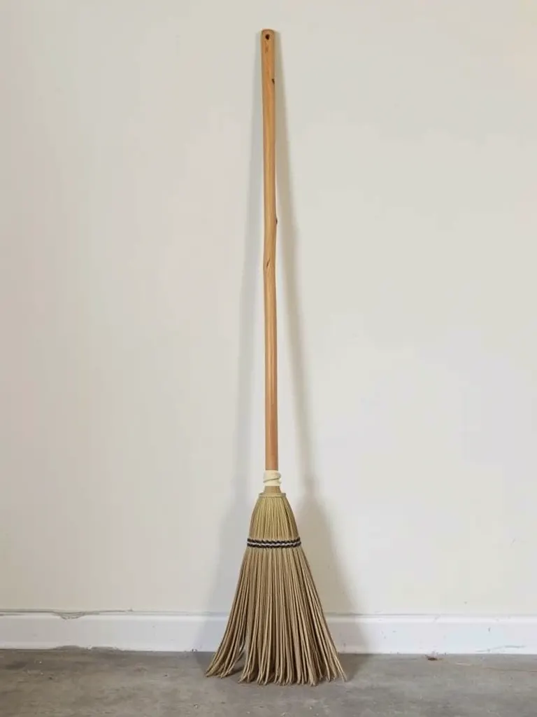 The yard broom standing against a wall